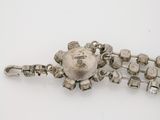 a close up of a silver bracelet on a white surface