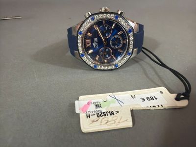 une montre à laquelle est attachée une étiquette, posée sur une table