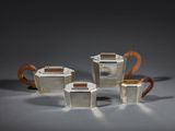 un service à thé et à café en argent composé de trois pièces, posé sur un support gris