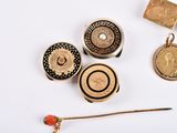 many different types of buttons and pins on a white surface
