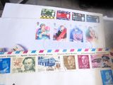 il y a beaucoup de timbres sur les enveloppes posées sur la table
