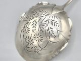 a silver spoon with a flower design on it