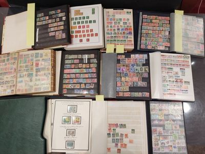 beaucoup de timbres posés sur une table, à côté d'un classeur