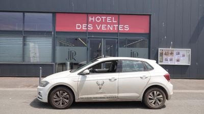 une voiture blanche garée devant un hôtel