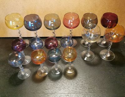 de nombreux verres à vin de différentes couleurs alignés sur une table
