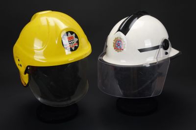 casques de chantier jaunes et blancs équipés de visières de protection, sur fond noir