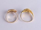 two gold rings with a wave design on the top and a wave design on the bottom