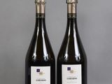 two bottles of wine sitting on top of a table next to each other