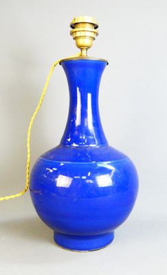 a blue vase with a gold handle on a table
