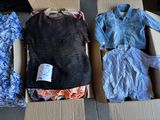 two boxes of clothes are sitting on a floor next to each other
