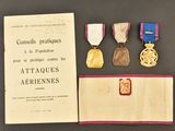 three medals and a certificate are sitting on a table