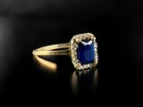 a close up of a gold ring with a blue stone