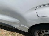 the front end of a silver car with a denting dent on it