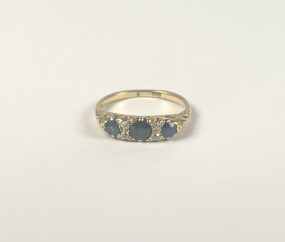 a close up of a gold ring with three sapphire stones