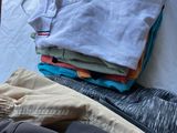 un tas de vêtements posé sur un lit près d'une fenêtre