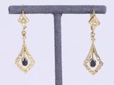 une paire de boucles d'oreilles en diamant noir et blanc, présentées sur un présentoir