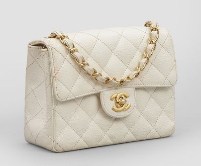 un sac à bandoulière Chanel en cuir matelassé blanc, avec des finitions dorées