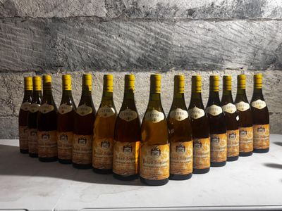bottles of wine are lined up on a table in front of a brick wall