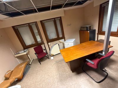 une pièce équipée d'un bureau, de chaises et d'une télévision
