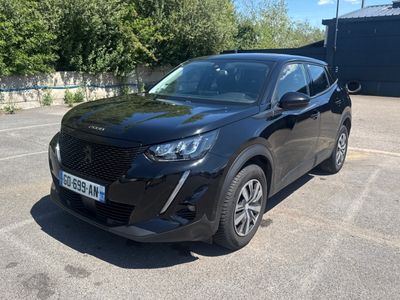 un SUV noir garé sur un parking, avec des arbres en arrière-plan