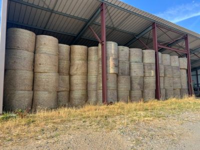 un gros tas de foin posé devant un bâtiment
