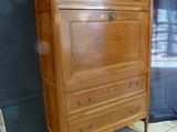 a wooden dresser with a marble top on a tiled floor