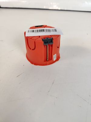 un petit objet rouge posé sur la table, sur lequel figure un code-barres