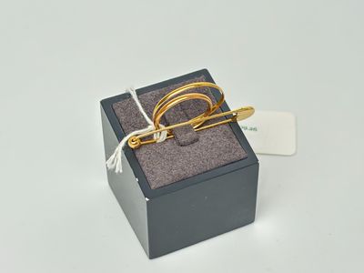 une bague en or dans un écrin noir posé sur une surface blanche