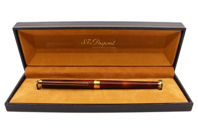 un stylo en bois dans un coffret noir orné d'une bordure dorée