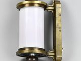 un gros plan d'un luminaire en laiton et blanc fixé au mur