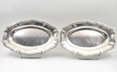 paire de plats argentés sur des socles, sur fond blanc
