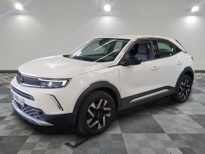 Le SUV blanc est garé dans une pièce au sol carrelé en damier.