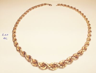 a close up of a gold necklace on a white surface