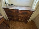 a wooden dresser in the corner of a room