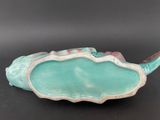 turquoise shell shaped dish with handle on black surface