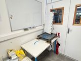 un tableau blanc accroché au mur dans une pièce équipée d'une table et de chaises