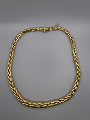 un collier en or avec un motif tressé sur fond blanc