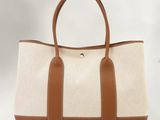 a white and brown tote bag sitting on top of a white table