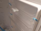 a white refrigerator with its door open in a kitchen