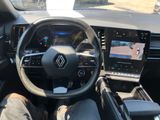 a man sitting in the driver ' s seat of a car with his feet on the steering wheel