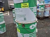 une pile de fûts verts et blancs sur lesquels est apposée une étiquette de prix