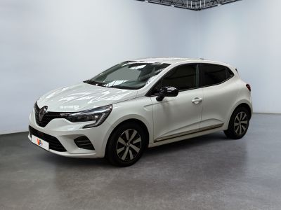 Une voiture blanche est garée dans une pièce blanche au sol noir