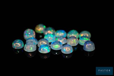un tas de perles d'oplite blanches sur une surface noire