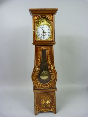 une horloge de parquet posée sur un socle devant un fond blanc