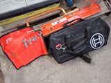 two tools and a tool bag sitting on the ground
