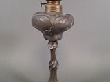 une lampe à huile ancienne en verre argenté, surmontée d'une couronne