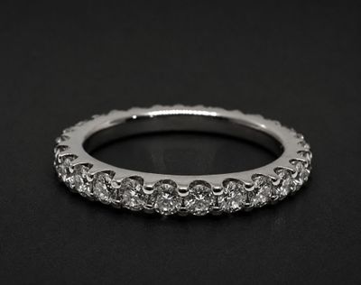 a close up of a diamond ring on a black surface