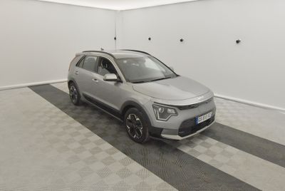 Le SUV gris est garé dans une pièce blanche dont le sol est à carreaux noirs et blancs.