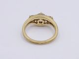 a close up of a gold ring with a diamond center