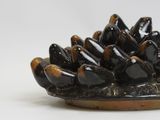 an image of a black and brown plate with a bunch of black birds on it